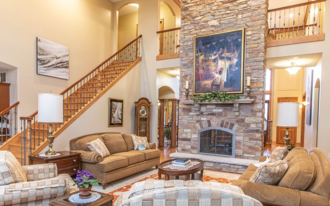 Spacious living room with vaulted ceilings, stone fireplace, and warm neutral furnishings designed for comfort and timeless living.