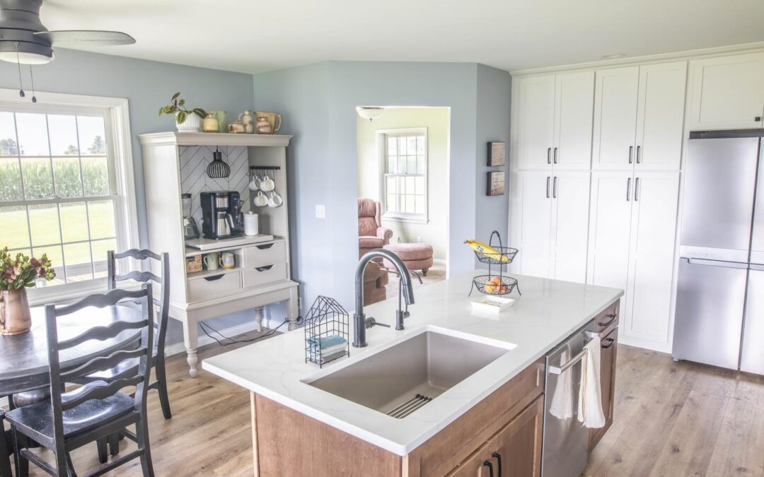 Kitchen renovation in Central Illinois with island, light blue walls, white cabinetry, and natural wood finishes by Shawluxe