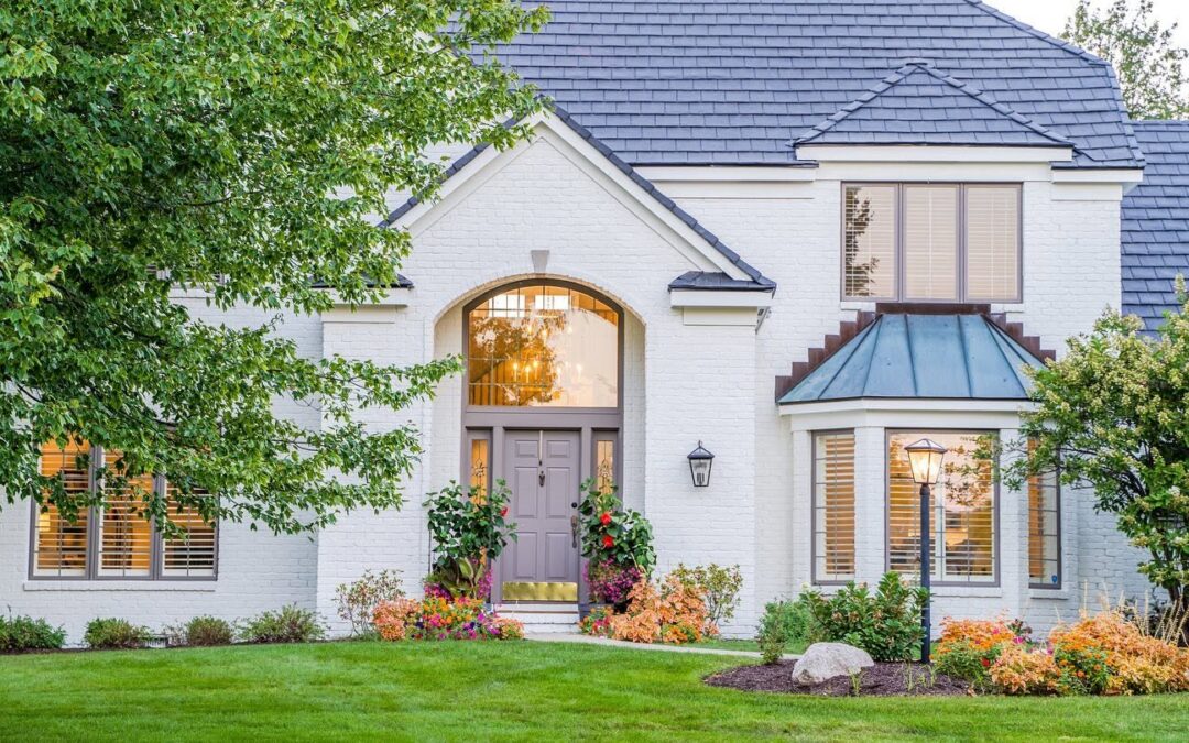 Beautiful white painted brick home with classic architecture, a professionally maintained exterior, and mature landscaping.